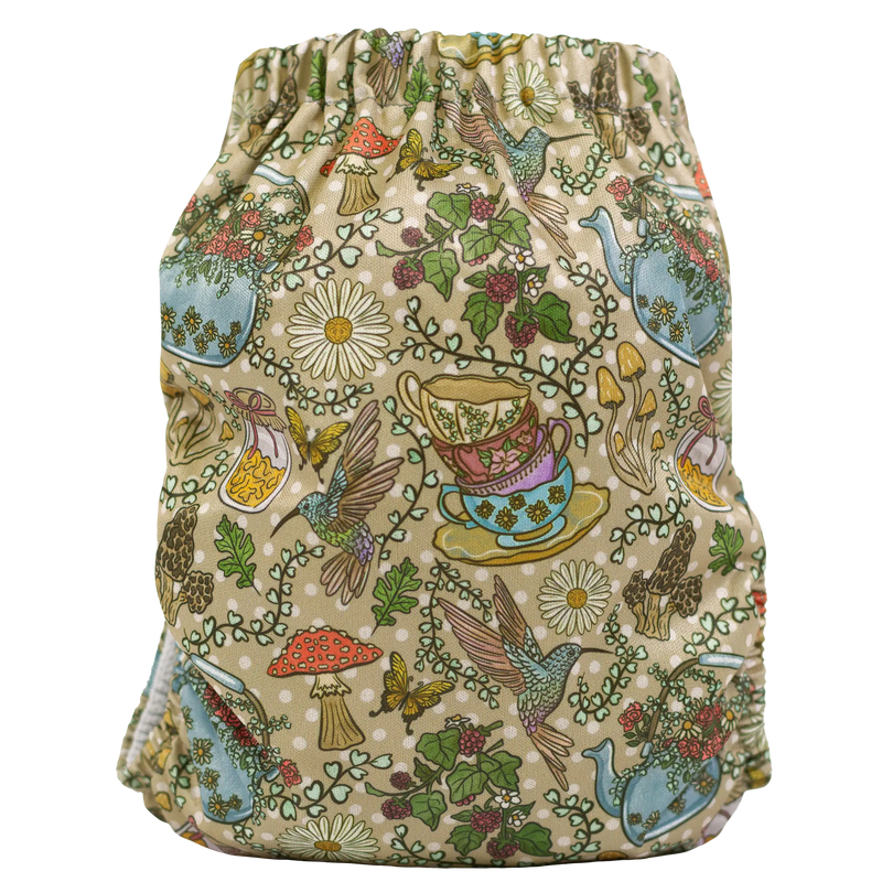 Colorful slim fit pocket cloth diaper with whimsical tea party design featuring teacups, birds, and flowers.