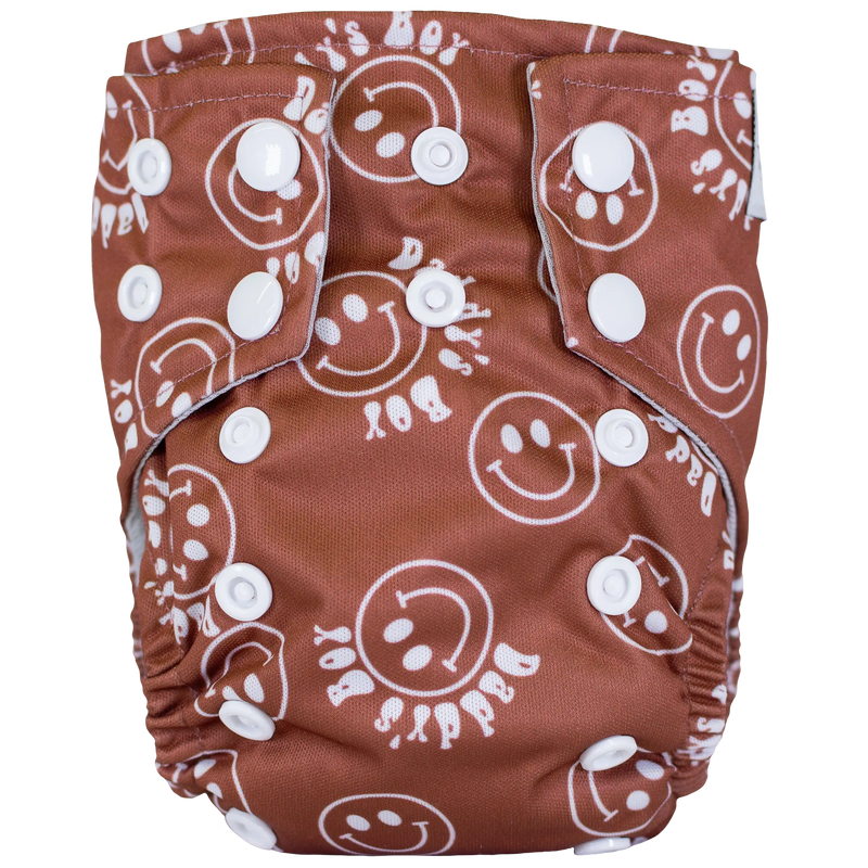 Tiny Tushies Newborn AIO Cloth Diaper with smiley face print and snap closures.