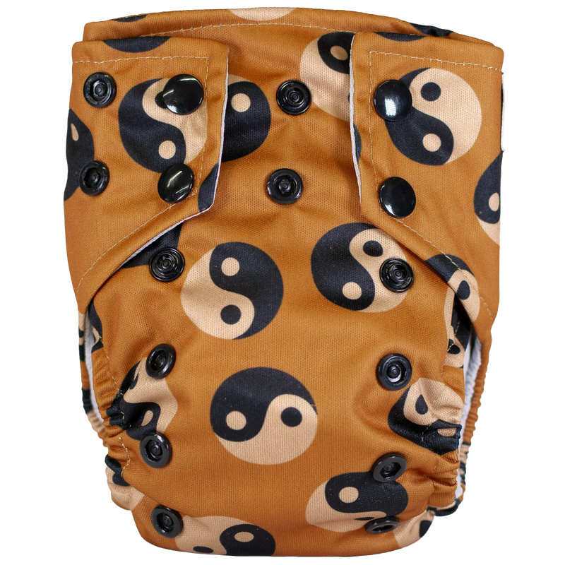 Tiny Tushies Newborn AIO Cloth Diaper with yin-yang design and adjustable snaps.