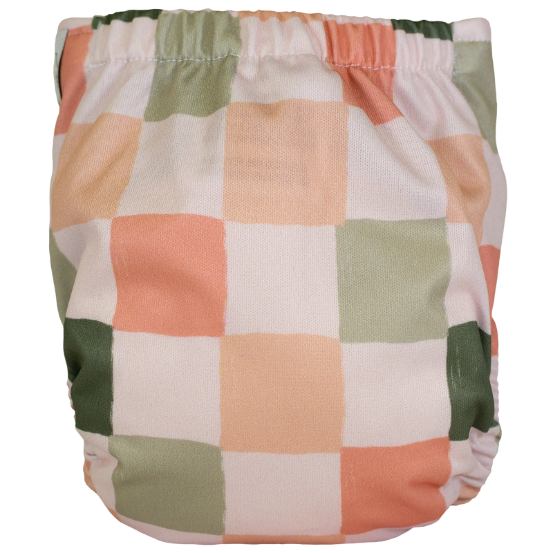 Multicolored checkered Tiny Tushies Newborn AIO cloth diaper with pocket opening.