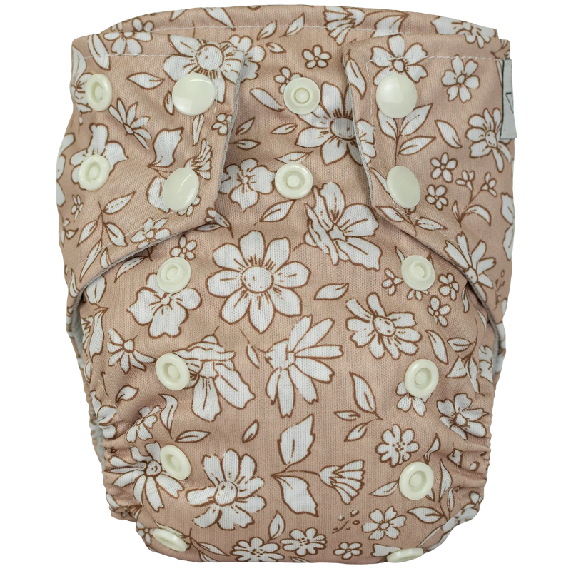 Tiny Tushies Newborn AIO Cloth Diaper with floral print fabric and secure snap closures.