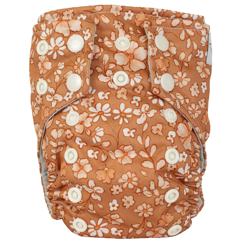 Tiny Tushies Newborn AIO Cloth Diaper with floral print and snap closures.