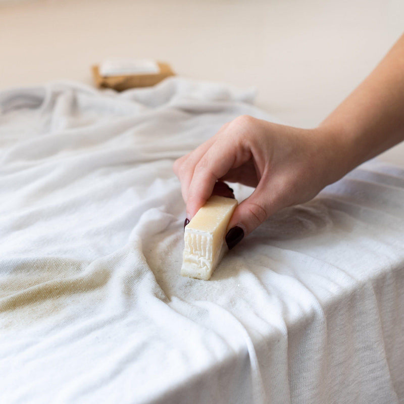 Laundry stain stick removing stains from white fabric.