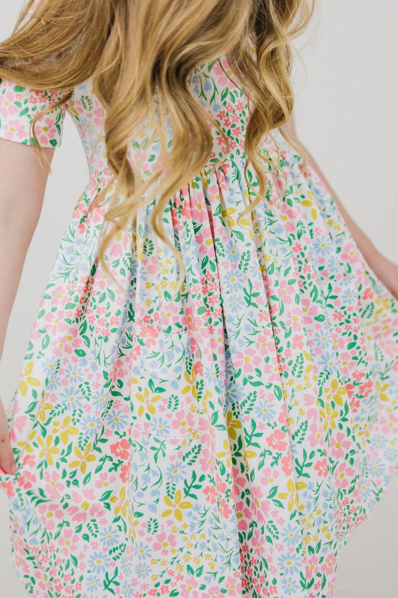 Short-sleeve twirl dress in a yellow daffodil print with pockets and a full twirl skirt