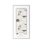 Cotton muslin swaddle blanket with a dinosaur print in soft muted colors, spread flat