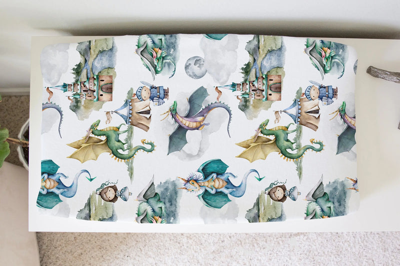 Dragon and knight patterned changing pad cover in soft fabric.