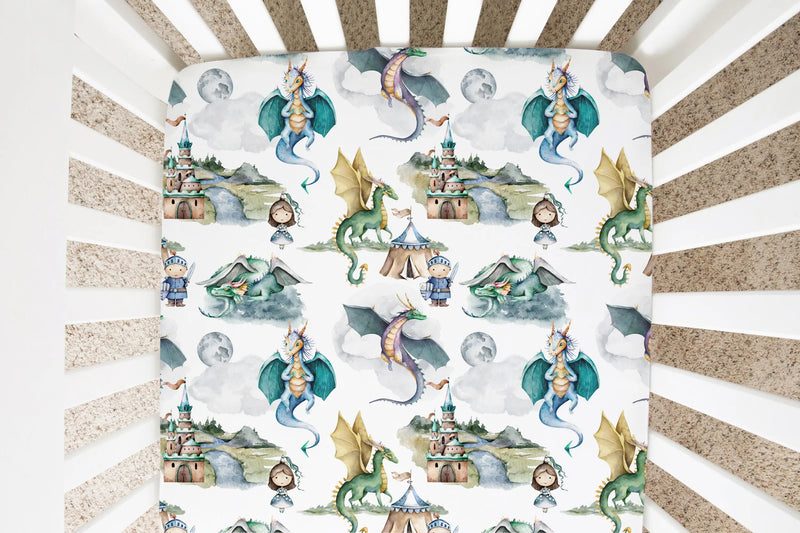 Fitted crib sheet with dragons and knights pattern in a crib.