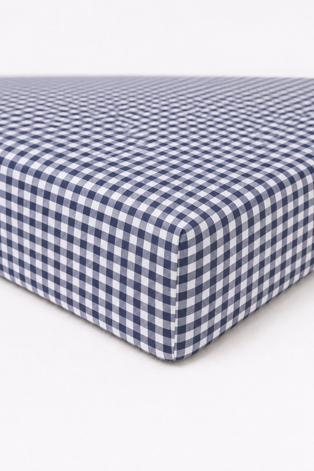 Navy and white gingham crib sheet fitted on a standard crib mattress.