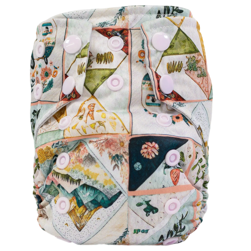 Tiny Tushies Newborn AIO Cloth Diaper with colorful pattern and adjustable snaps.