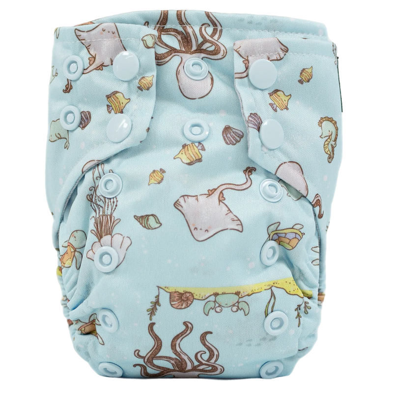 Tiny Tushies Newborn AIO Cloth Diaper with aquatic print and snap closures.