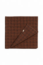 Quilted crib blanket with a brown and white diamond pattern