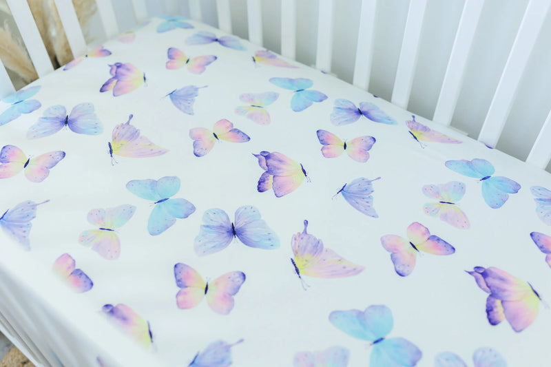 Butterfly patterned fitted crib sheet on crib mattress.