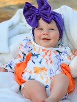 Long-sleeve girls romper with a Halloween bow print in festive colors and ruffle trim.