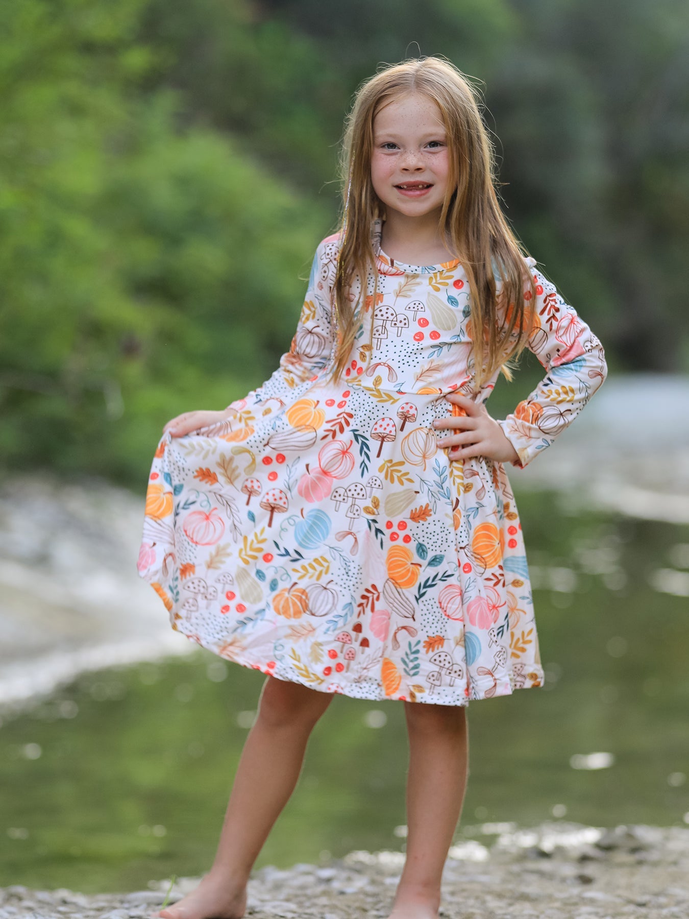 Girls' dress with an all-over pumpkin and autumn leaf print in fall colors.