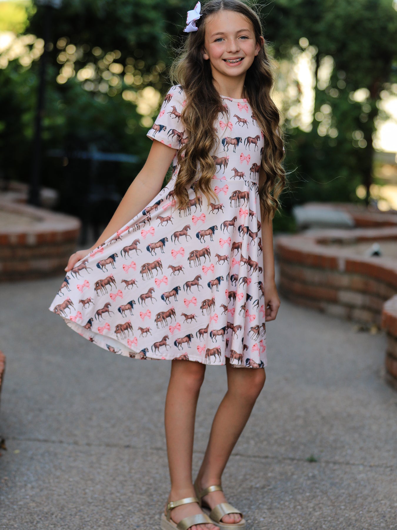 Short-sleeve twirl dress with an all-over western horse print, styled with a matching hair clip.