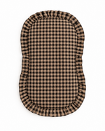 Baby lounger cover in brown and black gingham cotton with a ruffle trim along the top edge