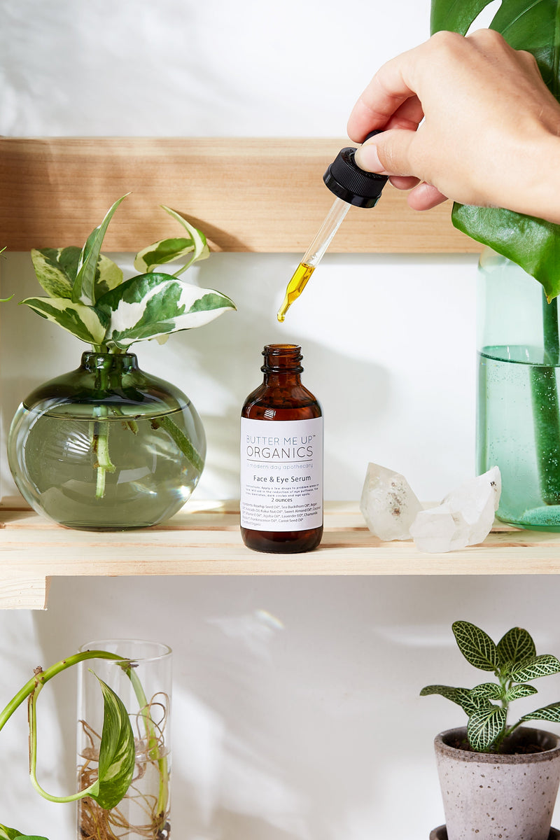 Organic Face & Eye Serum on a shelf surrounded by plants.