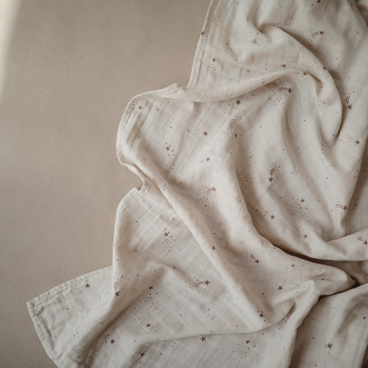 Mushie organic cotton muslin swaddle blanket, soft and breathable.