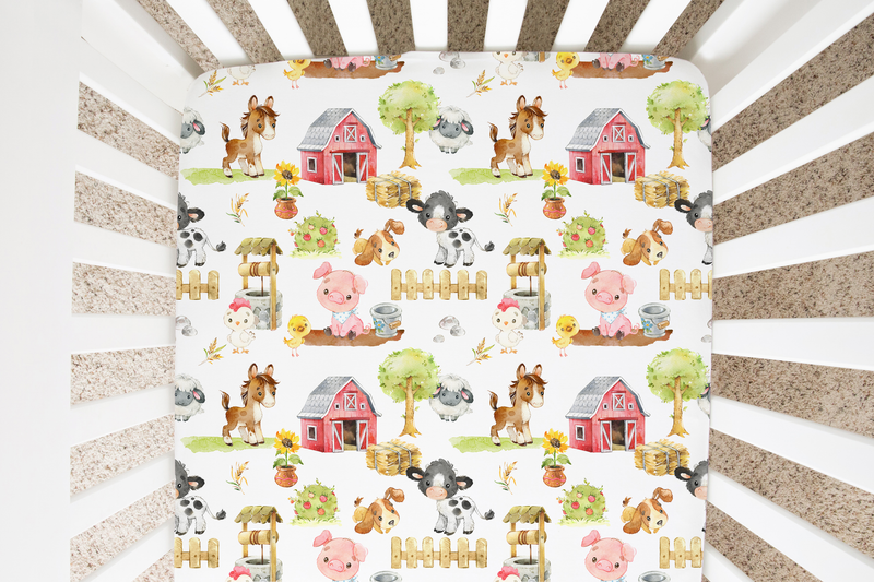 Fitted crib sheet with farm animals print in a crib.