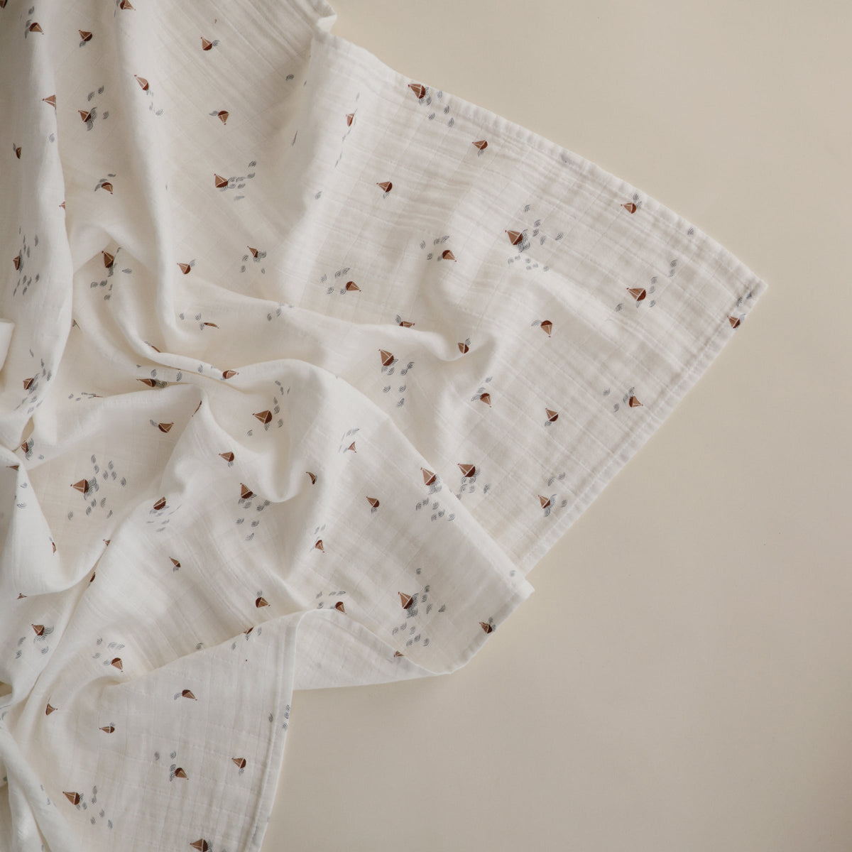 Mushie organic cotton muslin swaddle blanket, soft & breathable.