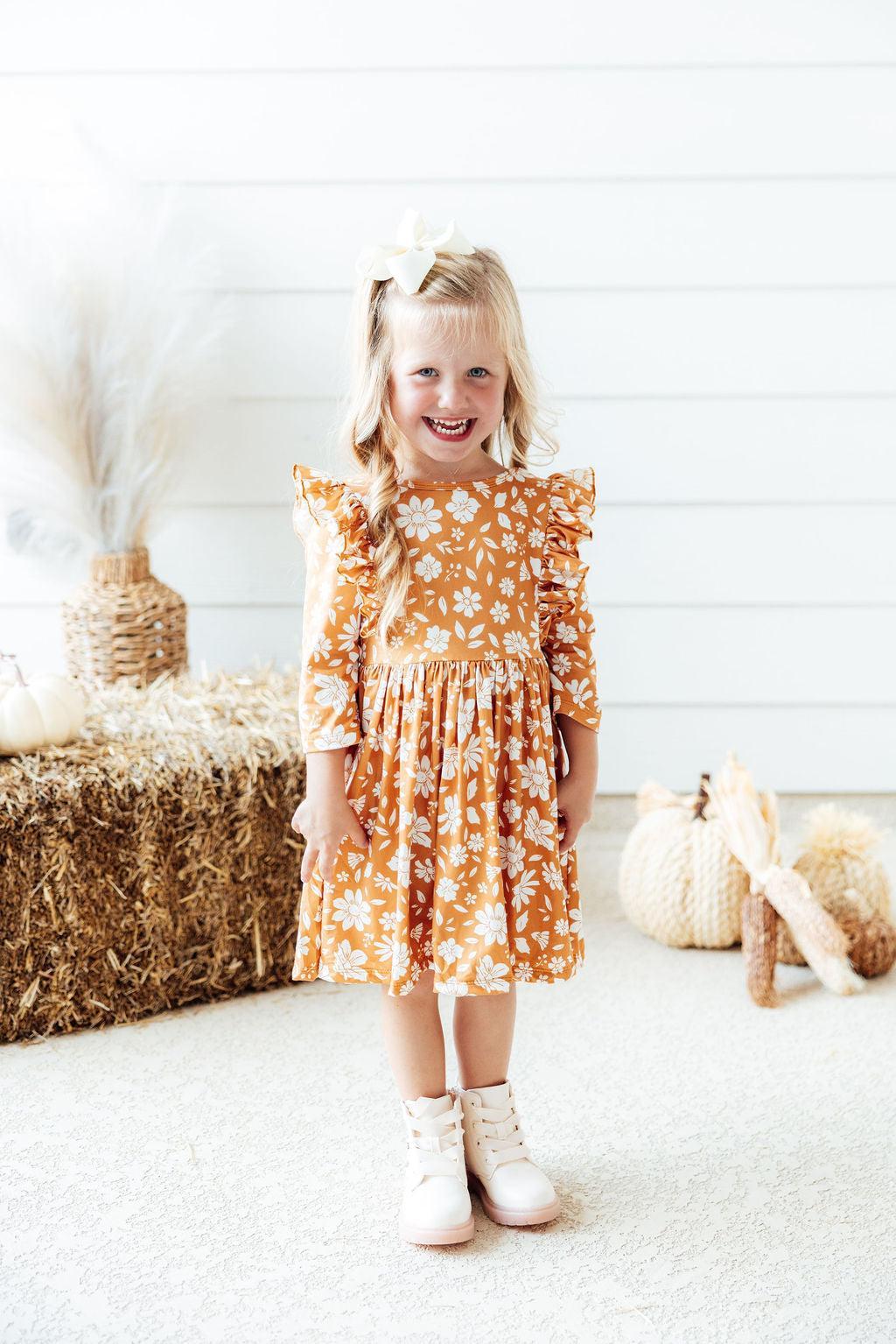 Twirl dress with golden floral print, 3/4 ruffle sleeves, ballet neckline, and full skirt.