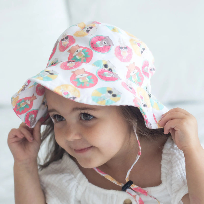 Baby wearing stylish "Keep Floating" sun hat with playful prints, providing UV protection.