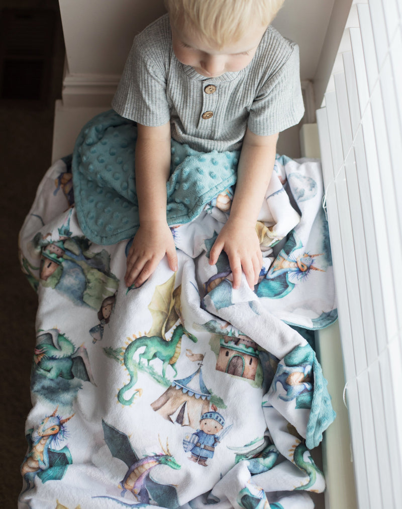 Baby sitting with Dragons & Knights minky blanket, soft texture, 30x40 inches, ideal for ages 0-3.