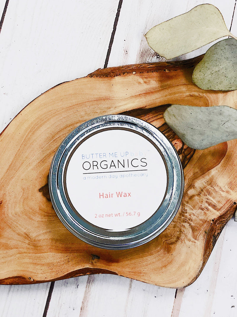Organic Hair Wax for Babies, Children, and Adults in a metal tin on a wooden board.