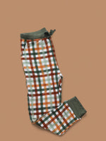 Toddler wearing organic autumn plaid joggers from Dream Big Little Co., playing on a soft rug.