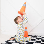 Long-sleeve two-piece pajamas with a construction and builder theme, worn by a child playing with toys.