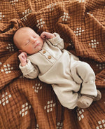 Baby wearing a soft, organic long sleeve cotton romper from LUCY LUE ORGANICS, gentle on skin.