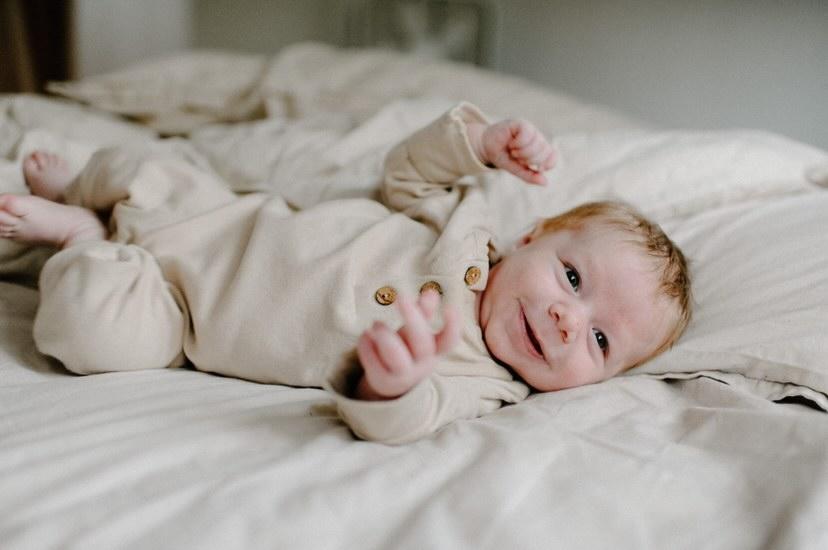 Baby wearing a soft, organic long sleeve cotton romper from LUCY LUE ORGANICS, gentle on skin.