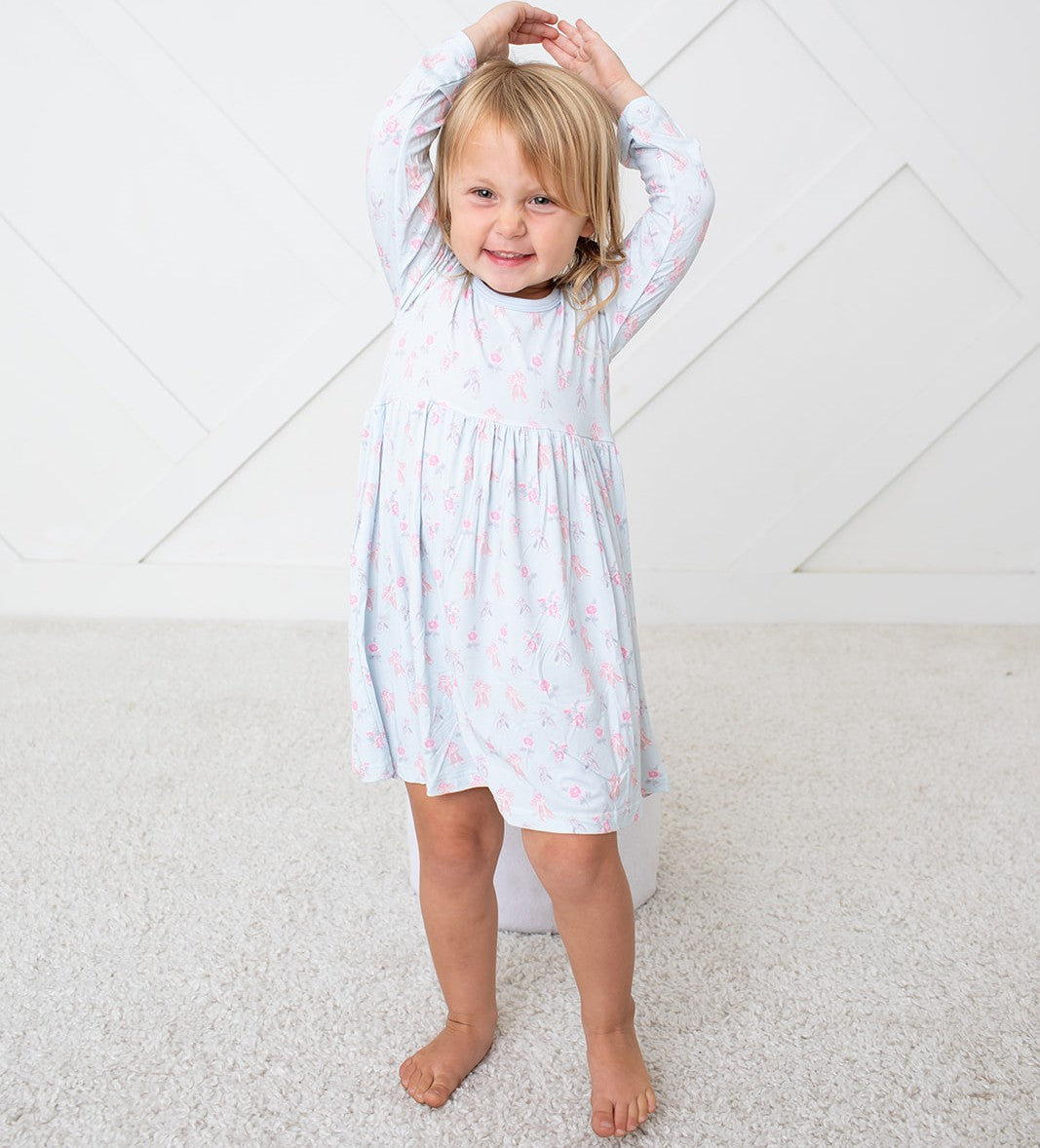 Pink long-sleeve toddler ballerina dress on a smiling child
