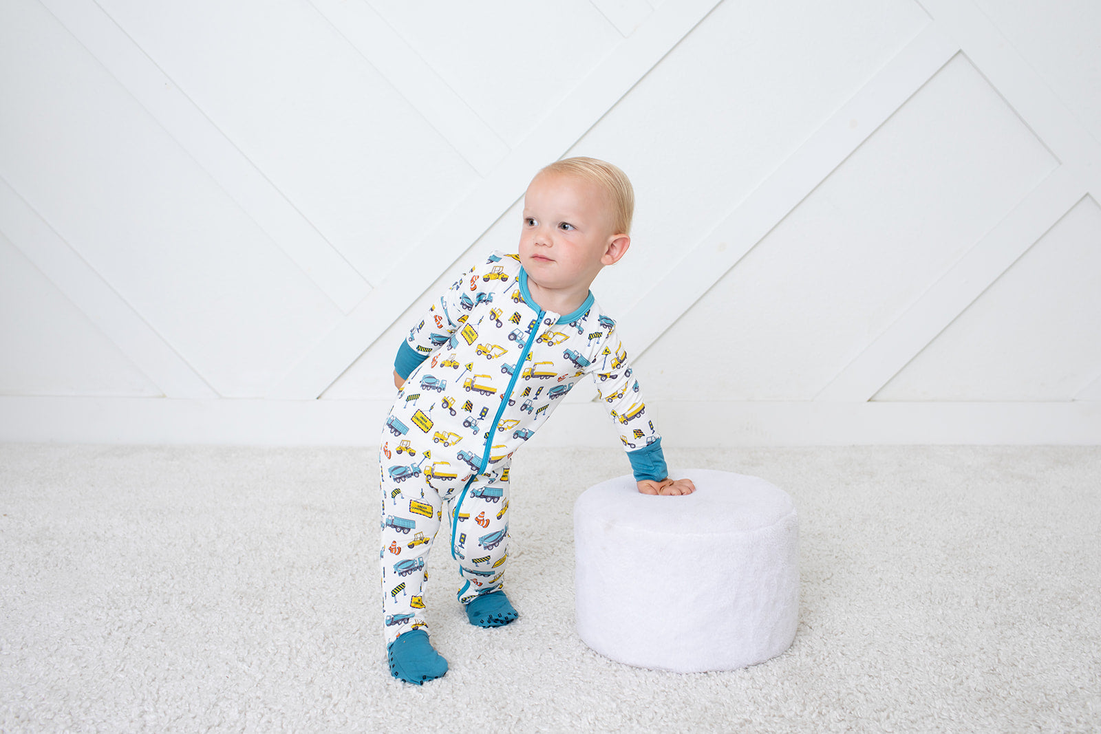 Baby coverall in a playful construction-themed print with long sleeves, footed legs, and a full-length two-way zipper.