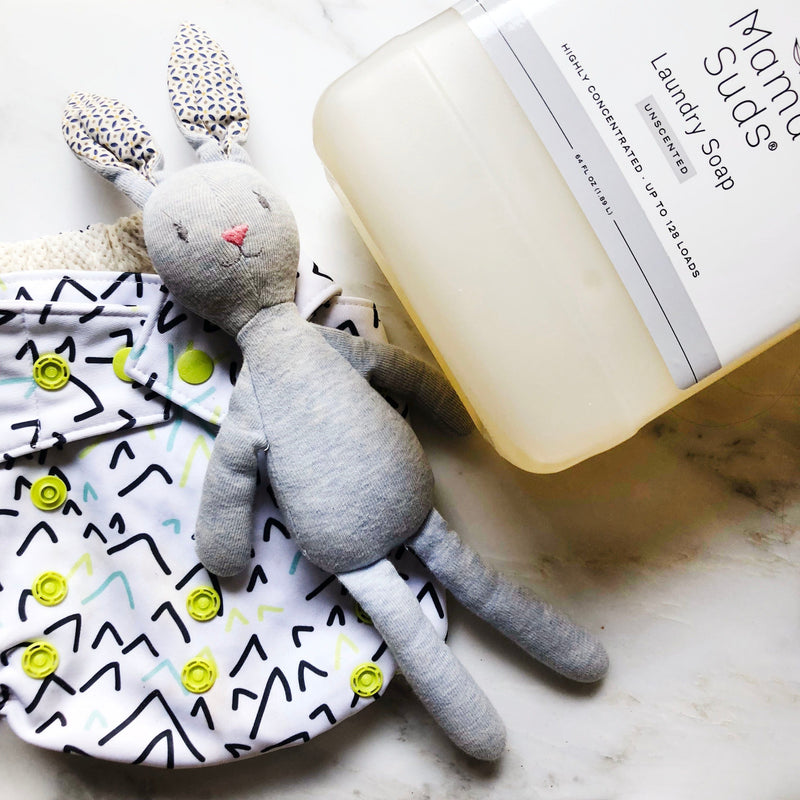 MamaSuds Laundry Detergent Soap with toy and cloth diaper.