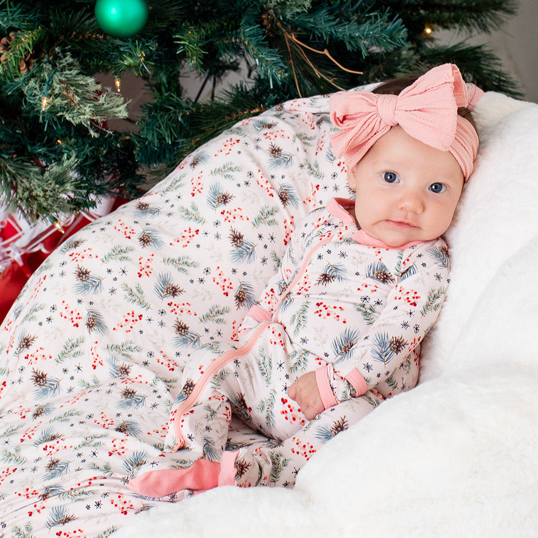 Baby footie pajamas with a pine tree pattern in pink, full-length zipper, and covered feet
