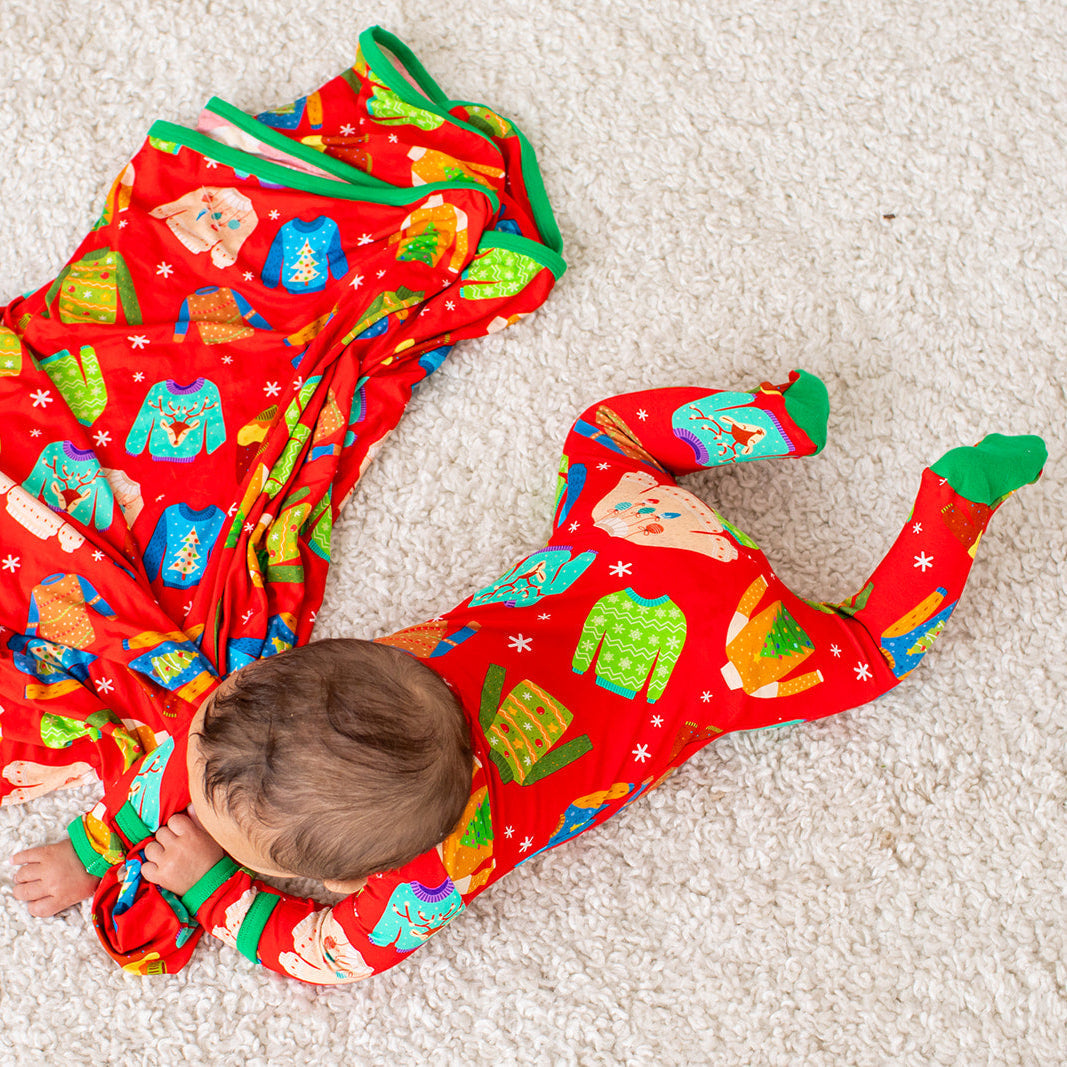 Baby footie pajamas with a festive ugly sweater party print, footed legs, and a full-length front zipper