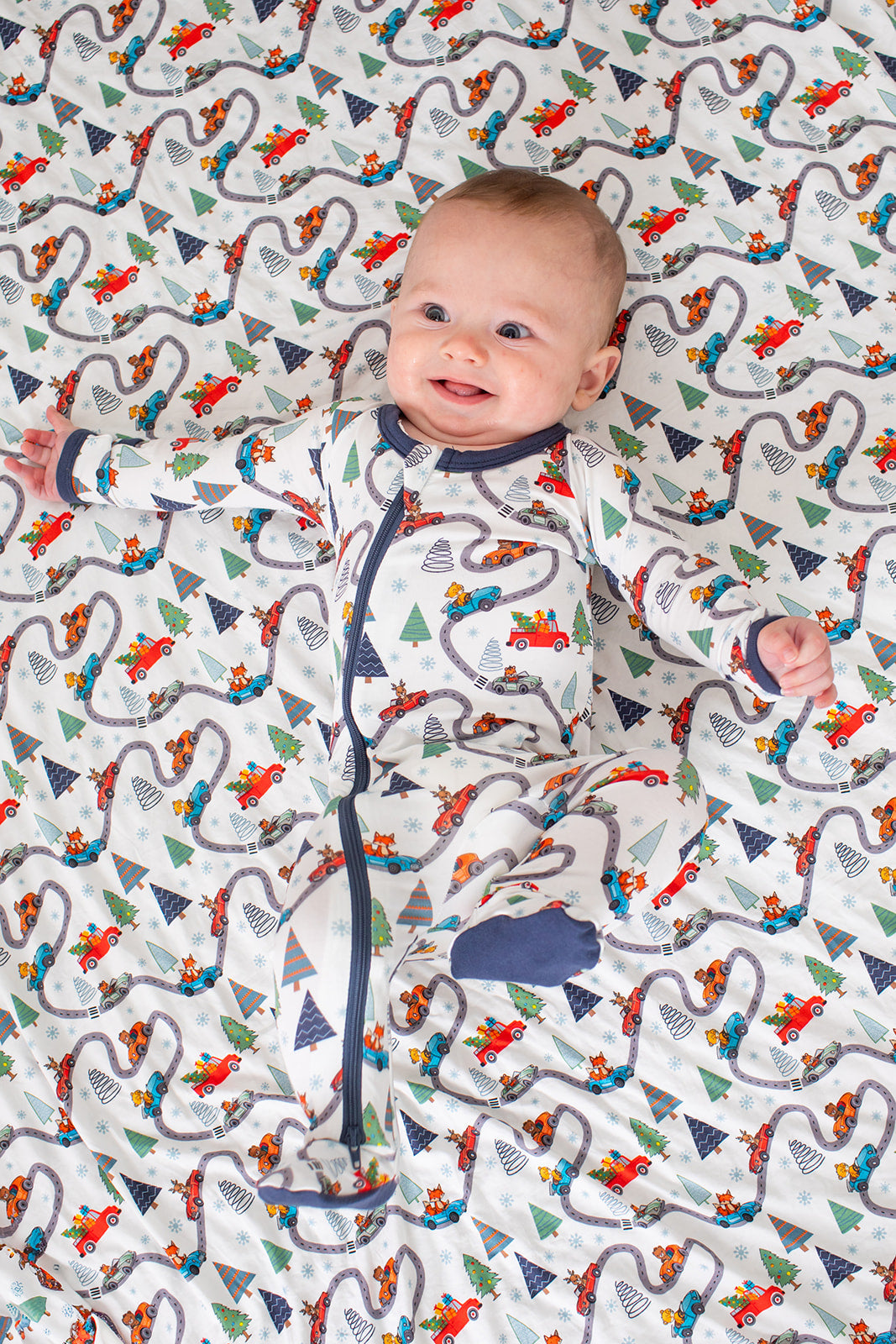 Baby footie pajamas with a holiday print, full-length zipper, and covered feet.