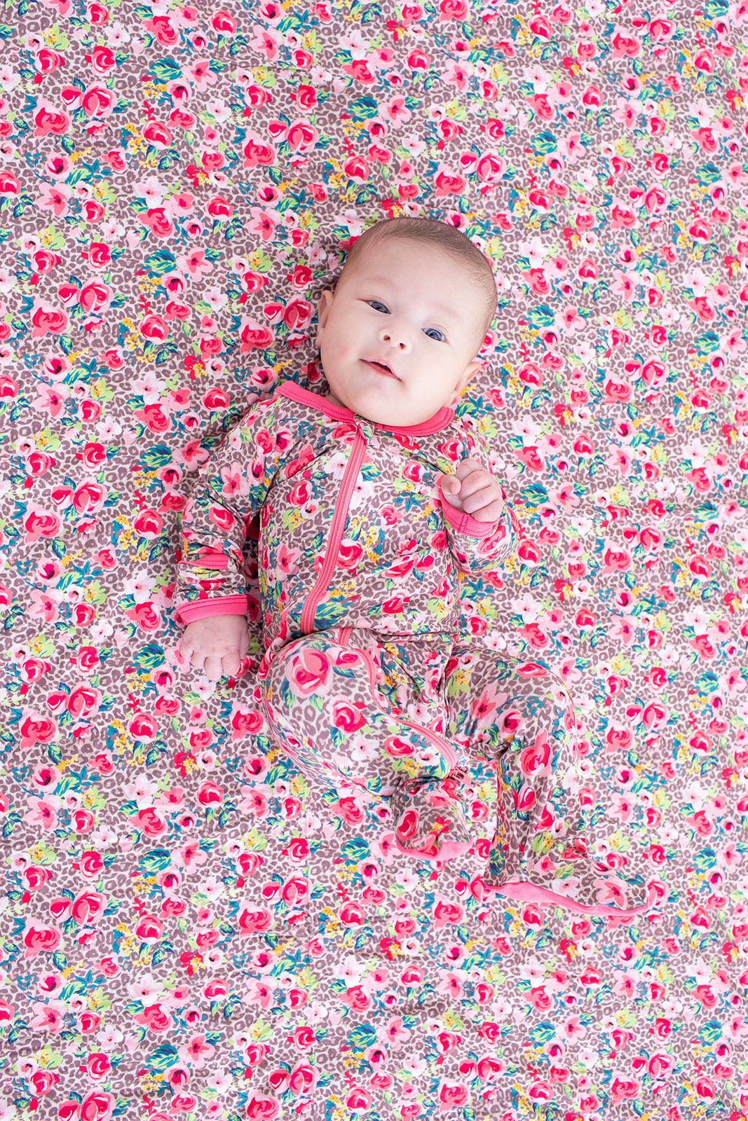 Baby footie pajamas in a pink Savanna Rose print with full-length two-way zipper and covered feet.