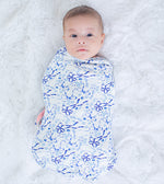 Swaddle blanket with blue bows, menorahs, Star of David and dreidels on a light background.
