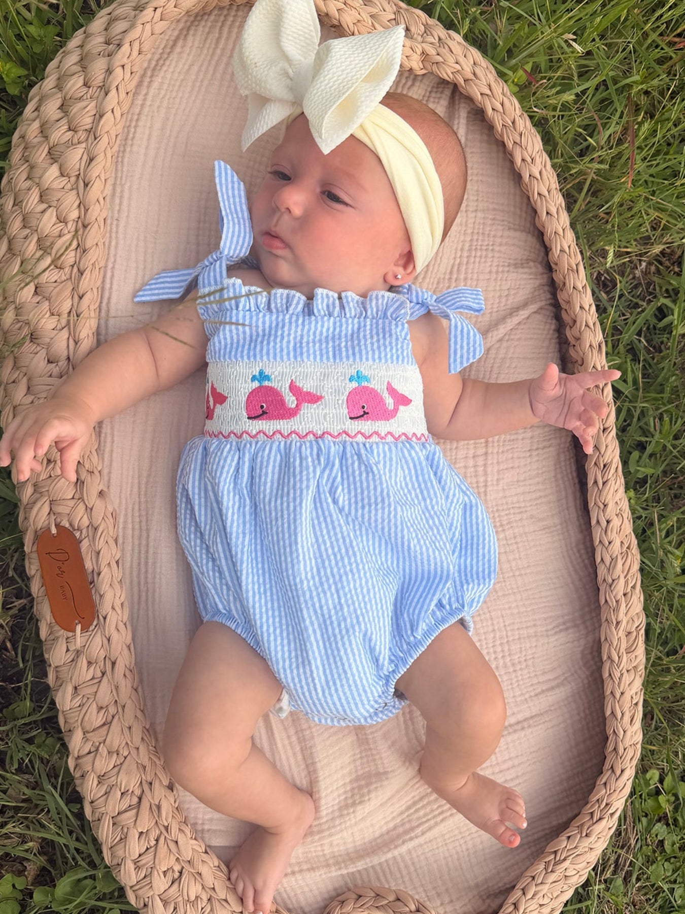 Seersucker striped baby girl romper with smocked panel, whale embroidery, and a bow