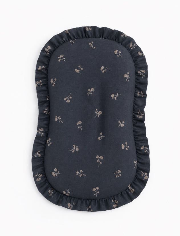 Baby lounger cover in blue dandelion print cotton with a ruffle trim along the top edge