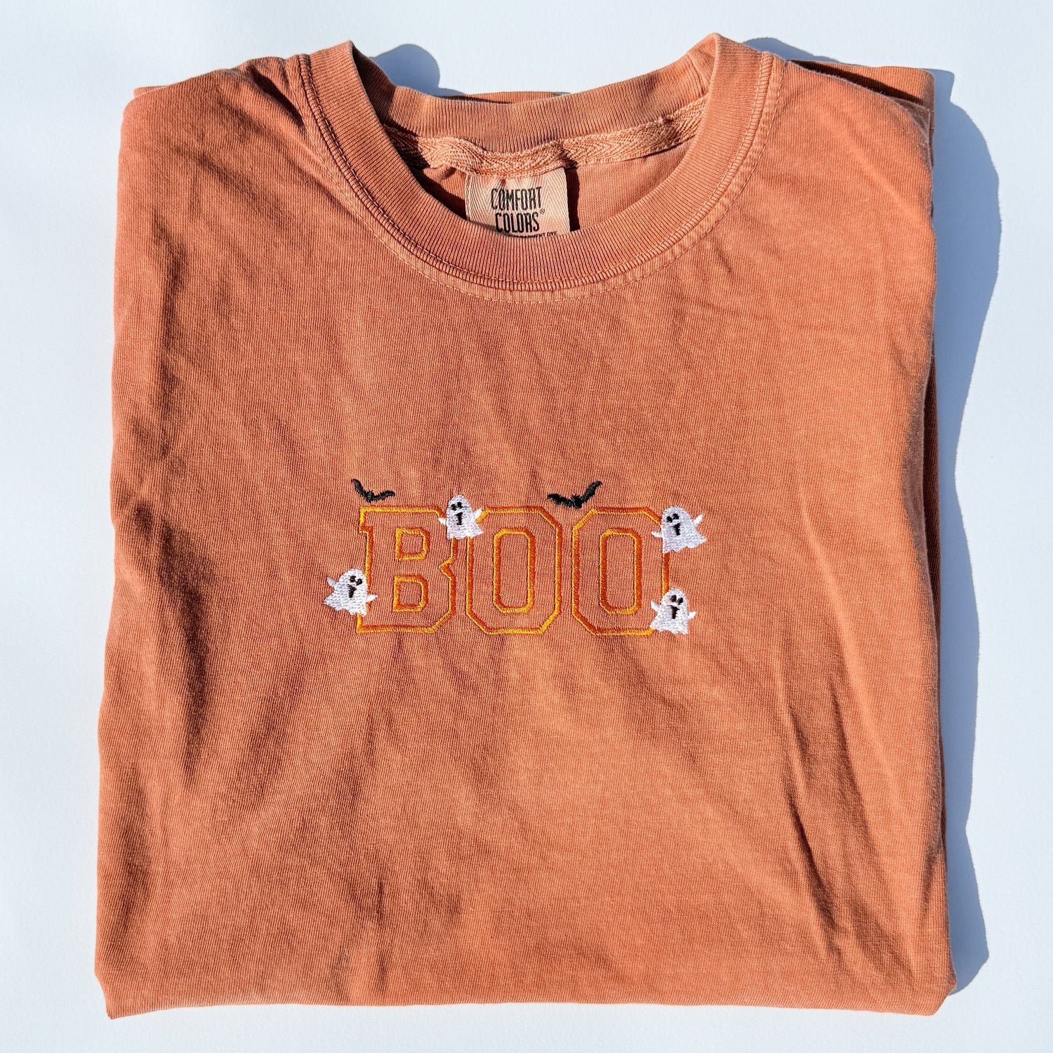 Rust-orange Comfort Colors adult tee with embroidered BOO Halloween lettering on the chest.