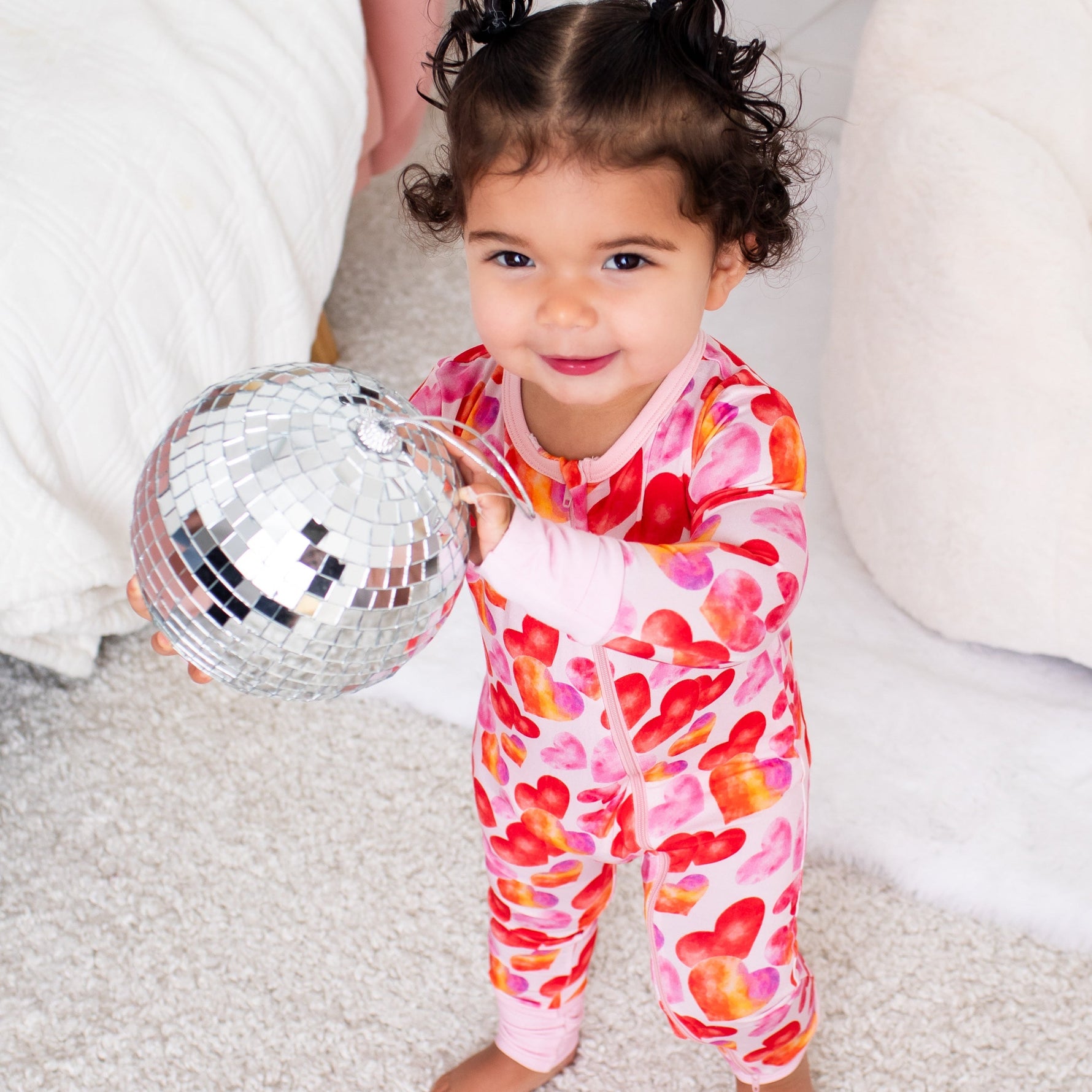 Convertible baby coverall in a love hearts print with a full-length two-way zipper and footed legs