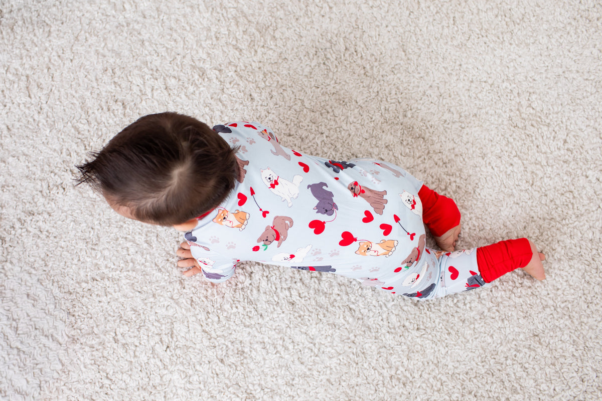Baby coverall with an all-over puppy print, long sleeves, and a full-length front zipper