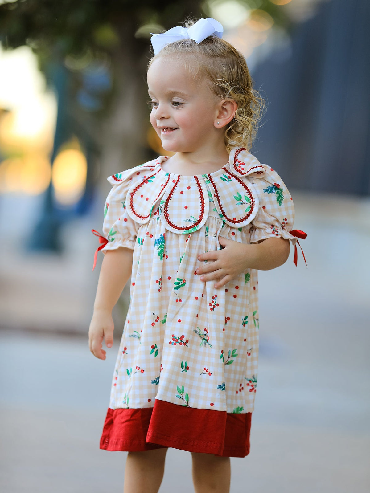 Girls dress in gingham print with a ruffle collar and small bow accents at the front