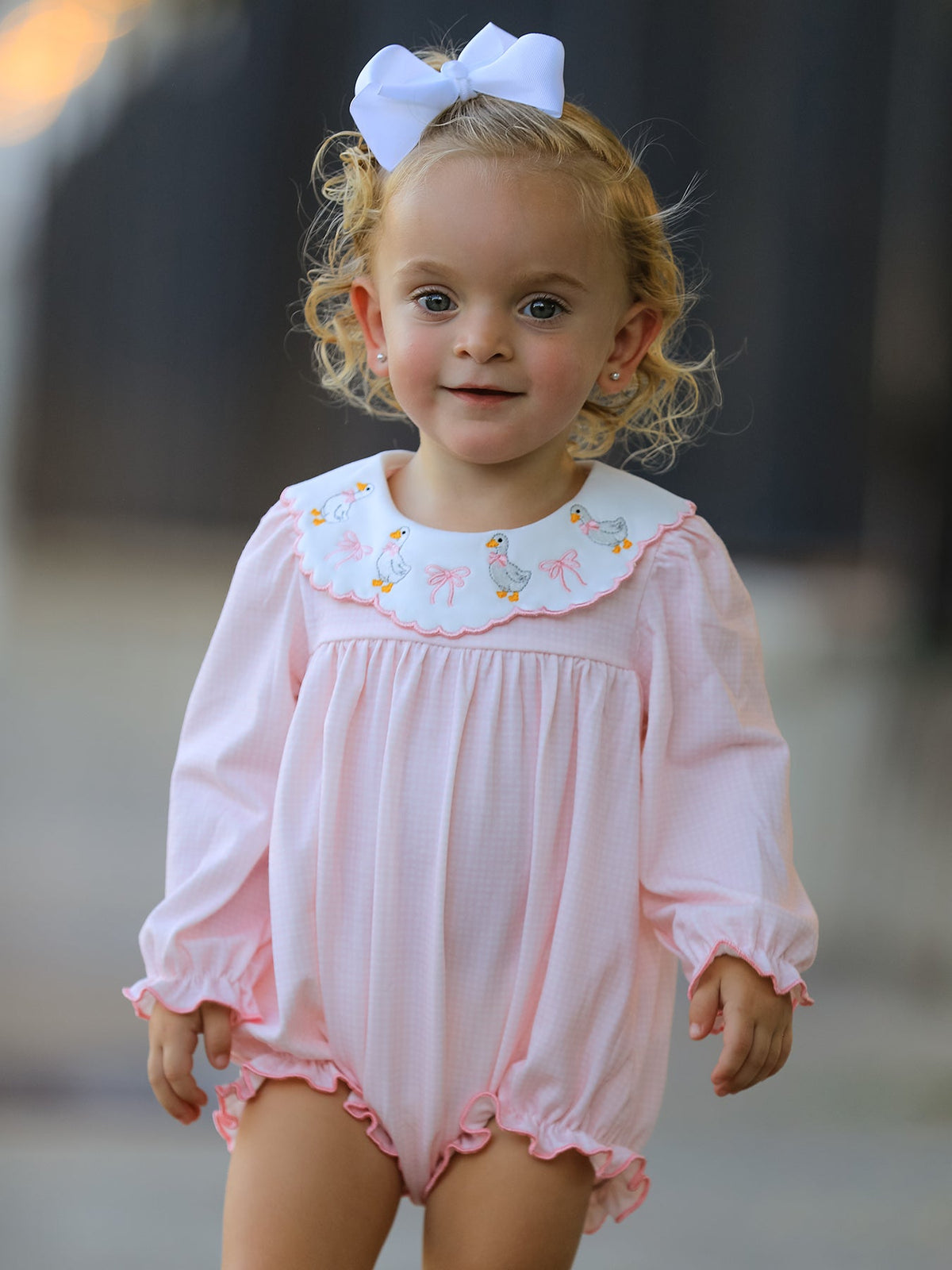 Long-sleeve baby romper with scalloped ruffle collar embroidered with a duck and bow, ruffle sleeve edges