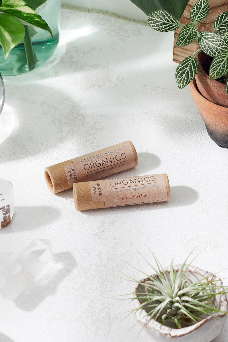Zero waste chapstick lip balm in paperboard tube, organic ingredients, kissable lips focus.