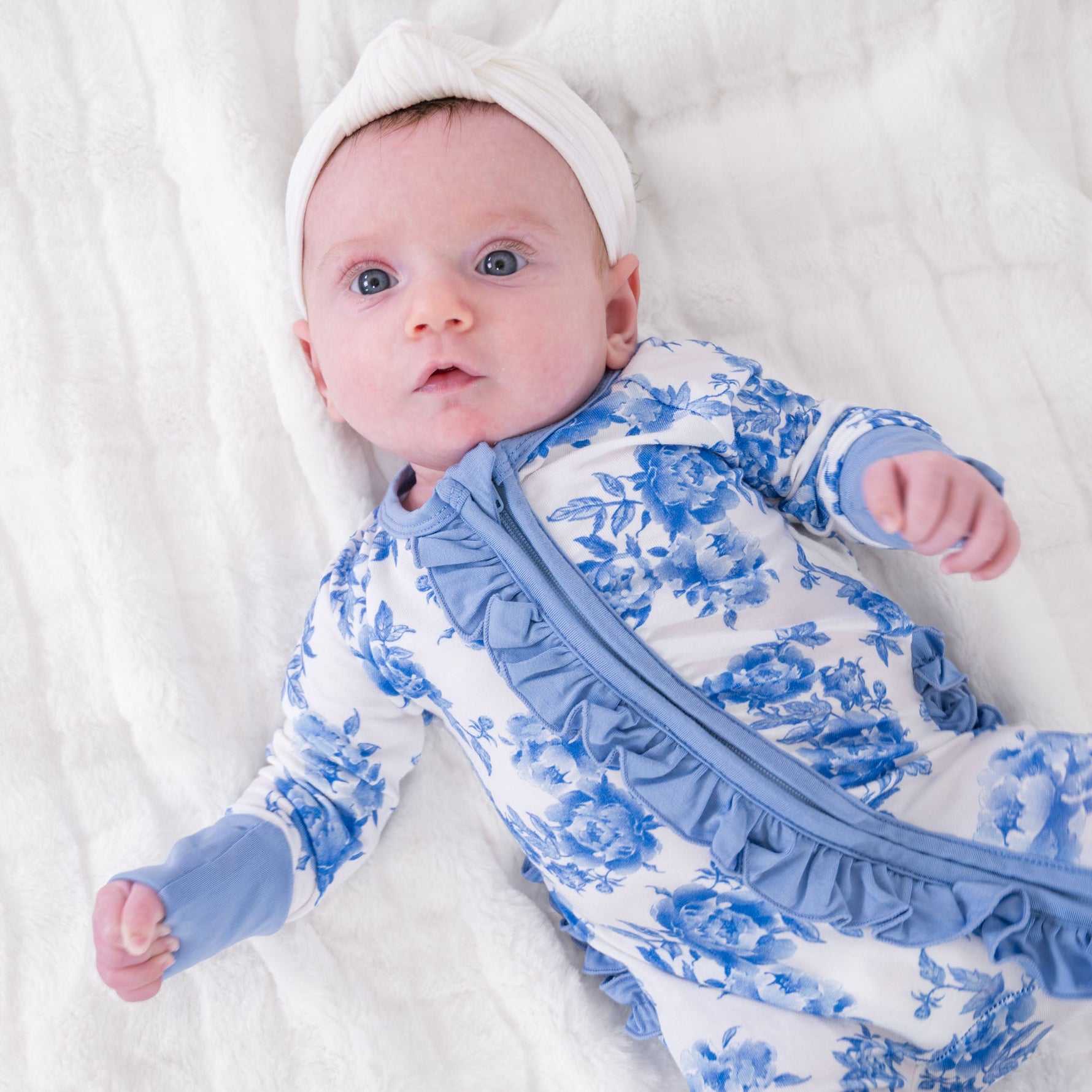 LollyBanks baby one-piece pajama with pink peony floral print and ruffles, front zipper closure.