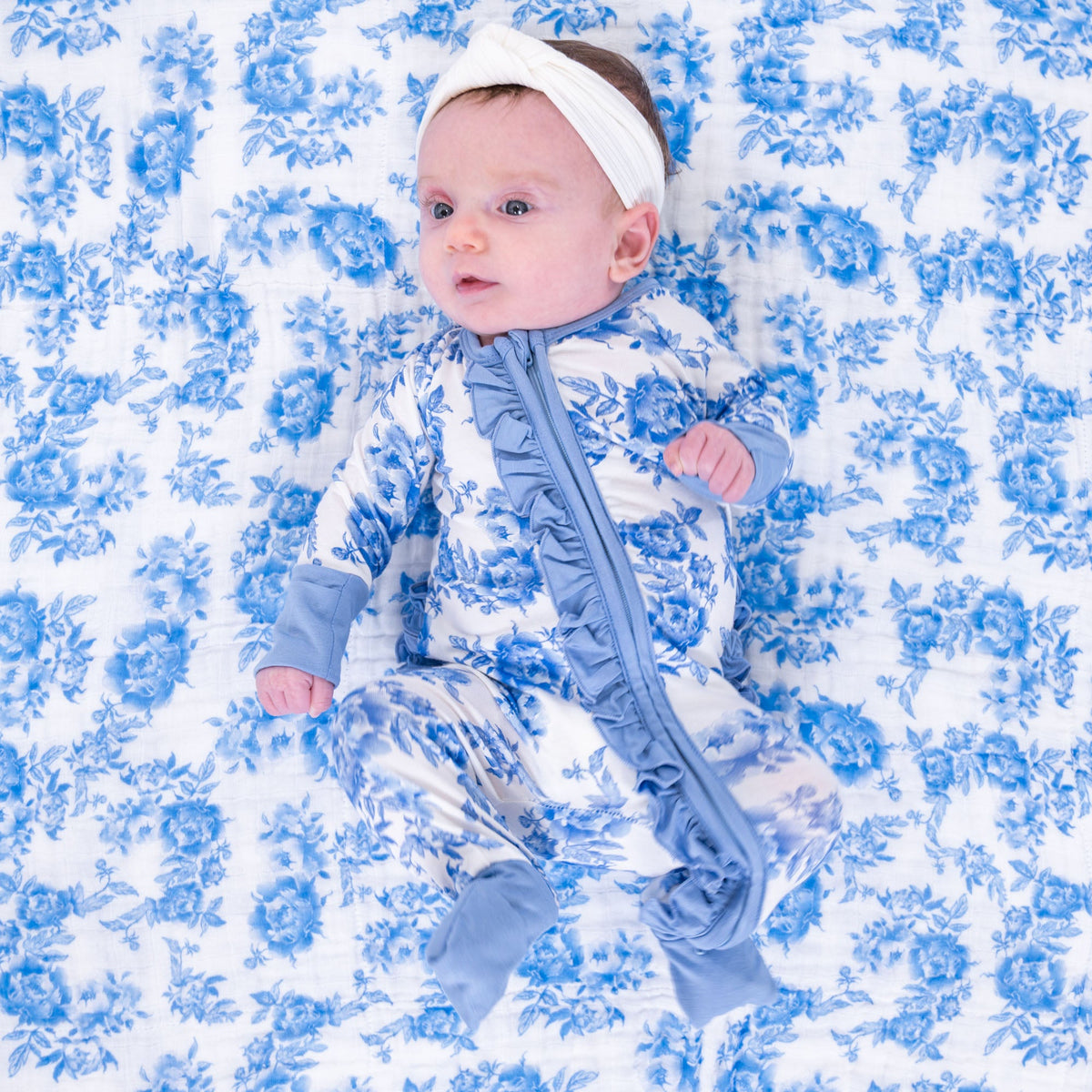 LollyBanks baby one-piece pajama with pink peony floral print and ruffles, front zipper closure.